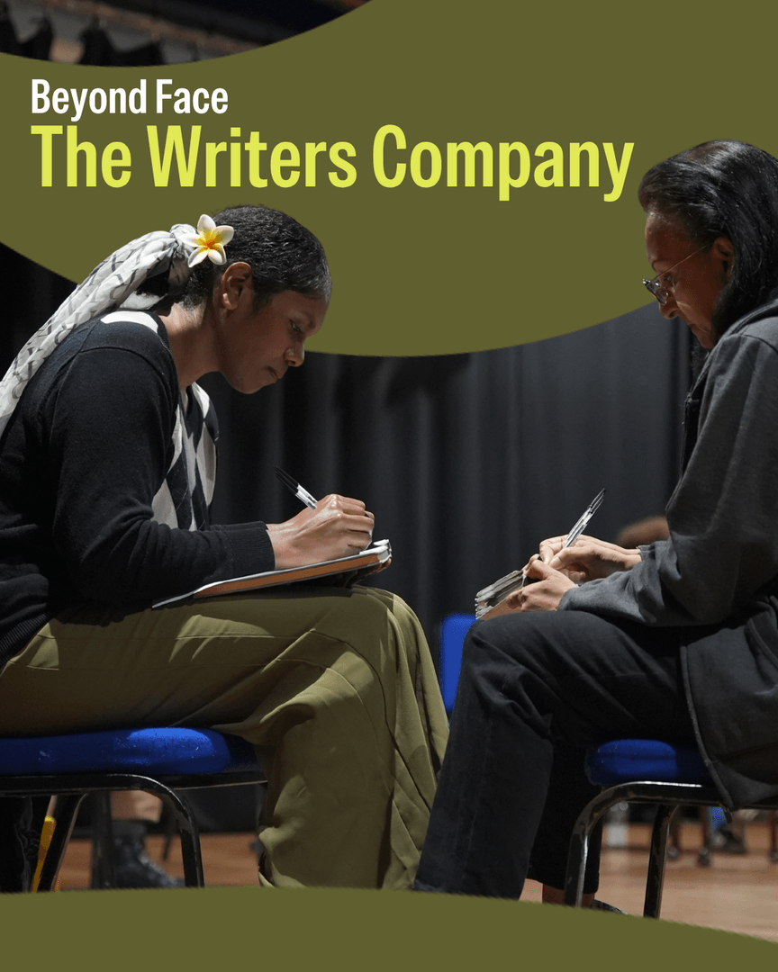 Two women are sat on chairs opposite each other writing
