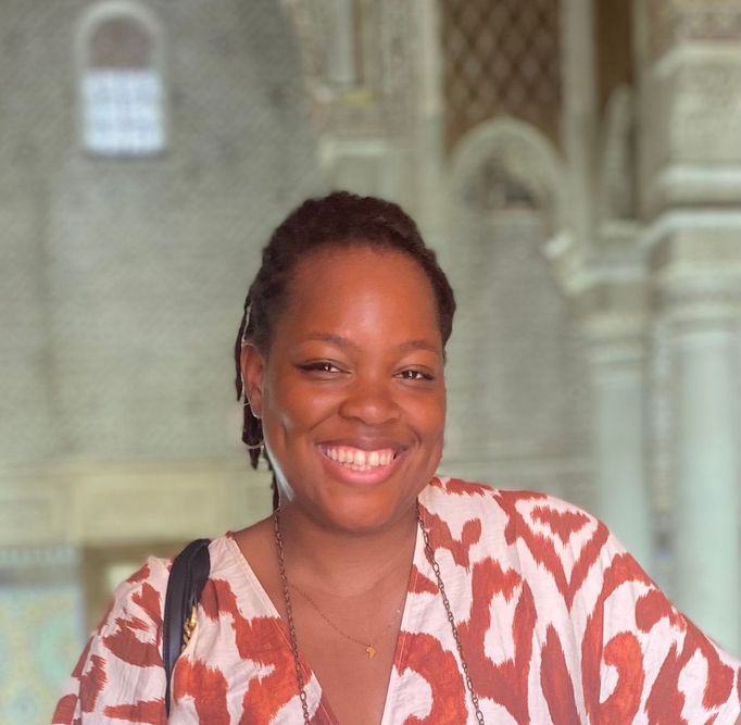 A woman is a smiling directly at a camera