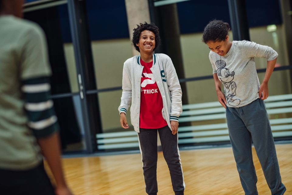 Photo of two young people standing in a studio area laughing together